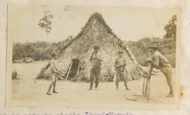 Índios em frente a casa indígena